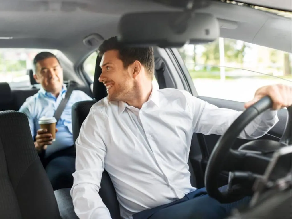 Chofer de empresa de transporte de pasajeros conversando con un cliente