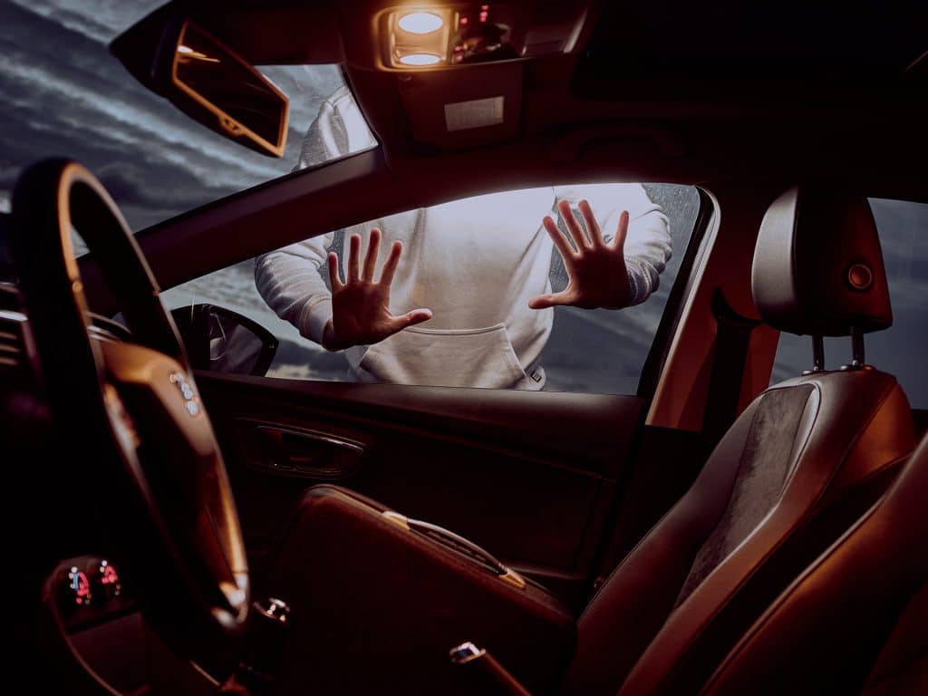 Persona poniendo sus mano sobre vidrio de auto.