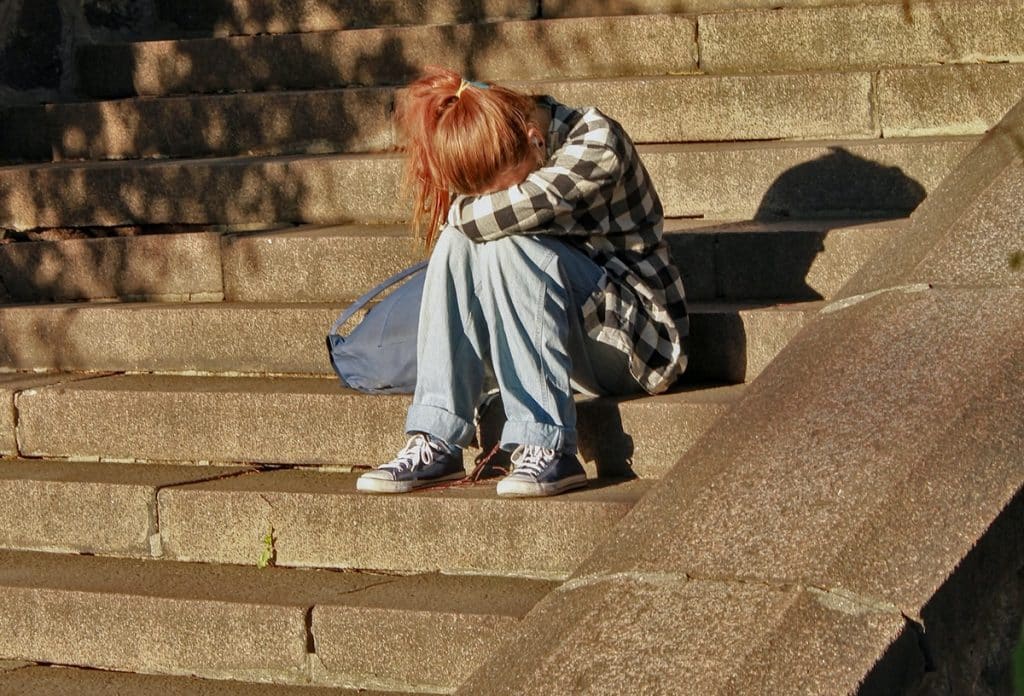 Mujer triste sentada en una escalera