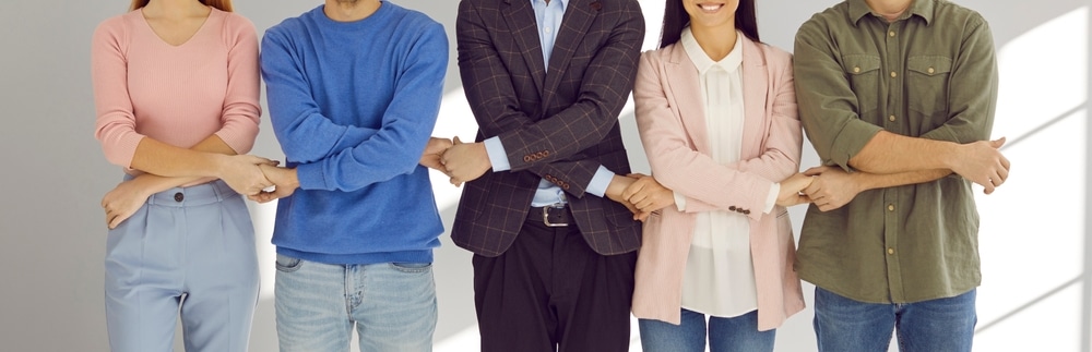 Imagen alegórica a responsabilidad social empresarial donde se muestra a un grupo de empleados tomados de las manos de forma entrelazada simbolizando el apoyo.